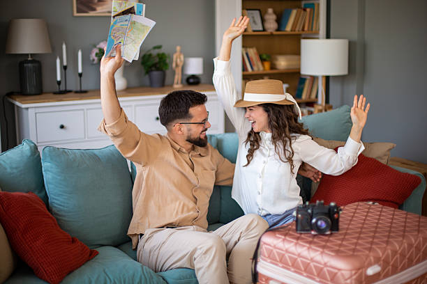 istock Young couple celebrating upcoming trip while sitting on sofa 2217521969