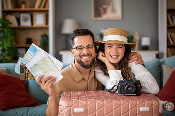 istock Happy couple planning summer vacation with maps and suitcase 2217522161
