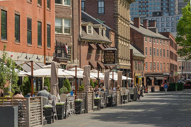 Boston, MA, US-April 16, 2025: Outdoor dining in the street in downtown district with Union Oyster House in background.