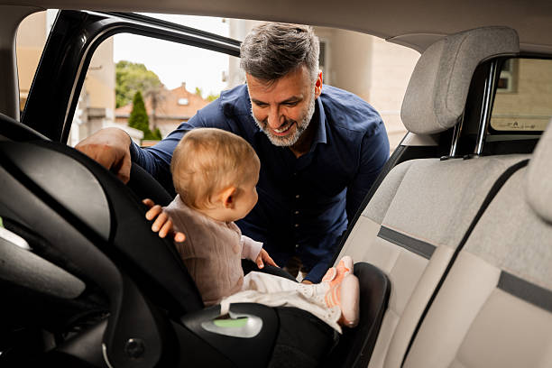 istock Father securing his baby daughter in a car seat 2217524949