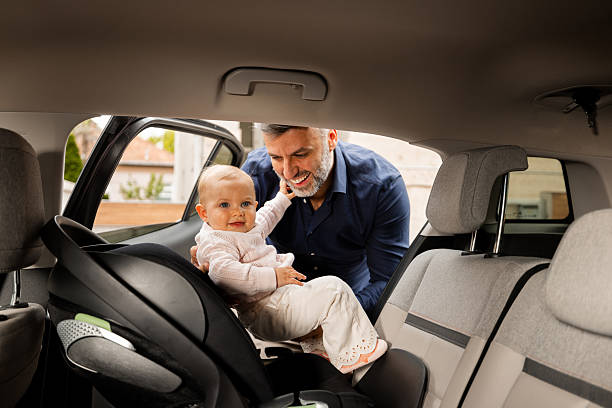 istock Father securing baby in car seat inside car 2217524958