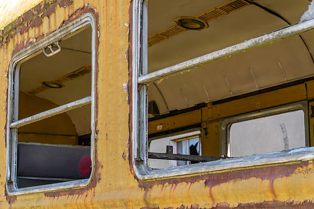 istock decaying yellow train car with peeling paint and broken or missing windows. The interior appears empty and worn, suggesting long-term neglect. 2217525338