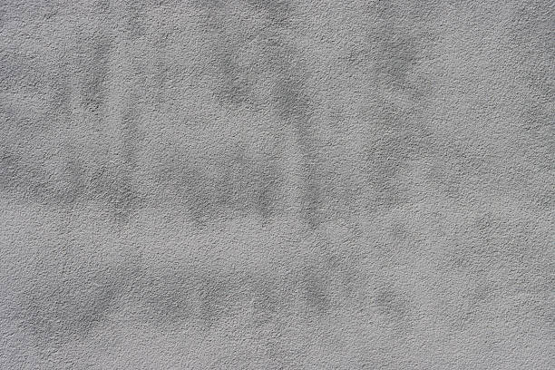 istock Weathered rough textured stucco wall painted gray-white. 2217525656