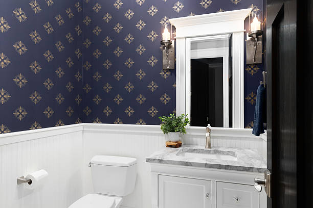 istock A bathroom with a blue and gold wallpaper and white cabinet. 2217528145