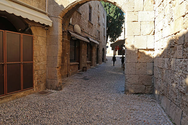 Arnauld Gate, Old Town, Rhodes, Greece, October 18, 2024. Narrow harbour side entrance gate to the town through fortified walls. Ancient medieval walled town and capital city. Sunny day outdoors.