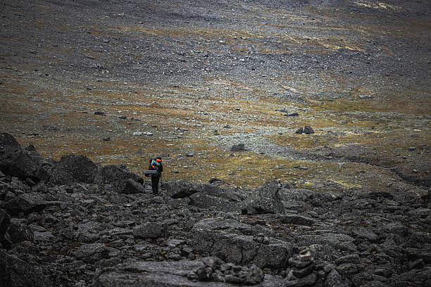 istock Hiker navigating a rocky terrain in an expansive wilderness landscape 2217529476