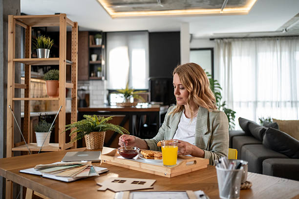 istock Female architect eating breakfast and working at home office 2217530029