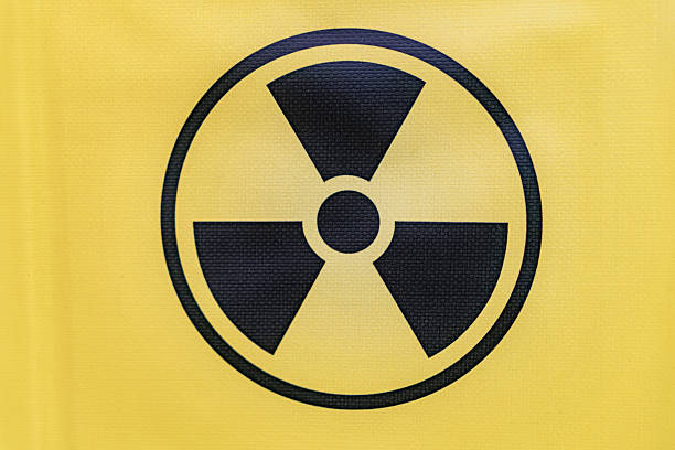 Yellow radiation symbol on fabric, possibly clothing. three radiating lines emanating from a central point, which is typically interpreted as a warning or indicator of nuclear activity or danger