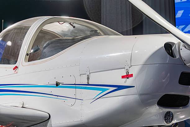 istock Single-engine white and blue aircraft with high tail structure, visible cockpit, indoors setting likely in an exhibition booth, bright lighting 2217531528