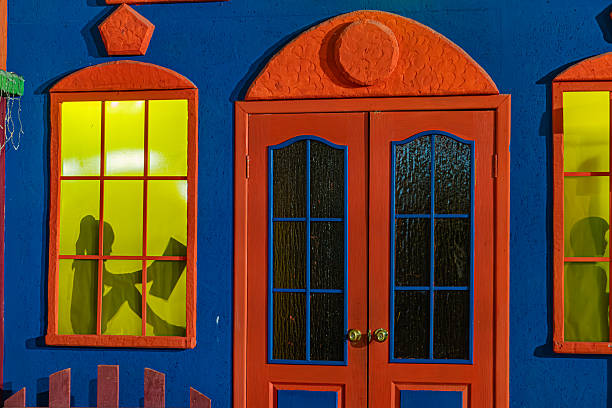 istock A nighttime photo of a multi-storied, blue building with three red-framed windows on the left and two sets of red and glass doors on the right The interior is artificially lit, with no visible peopl 2217531695