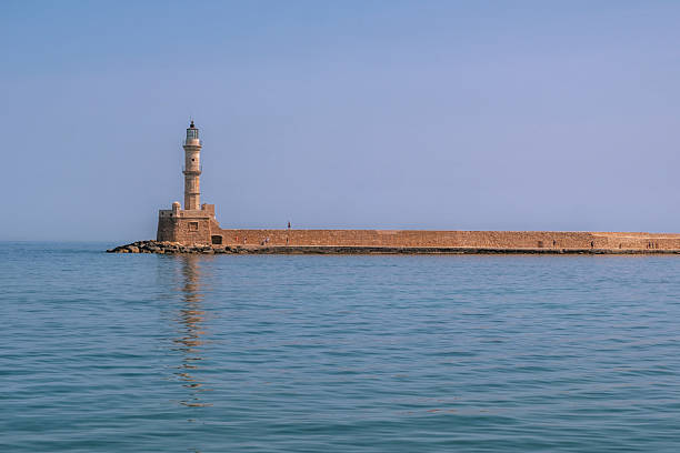 Valletta, Malta - April 17, 2025: Lighthouse and St. Elmo Breakwater, leading from Fort Saint Elmo through Grand Harbour, surrounded by calm blue water of Mediterranean Sea