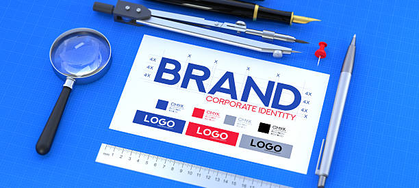 A 3D animation conceptualizing the meticulous process of brand creation and corporate identity development. A branding guide, laid out like a blueprint on a blue cutting mat, is surrounded by essential design tools: a magnifying glass for research, a compass for precision, and a pen for execution. This image is a powerful visual metaphor for the strategy, planning, and creativity involved in graphic design and marketing. It's ideal for design agencies, business presentations, and educational materials that focus on building a strong, coherent brand from the ground up.