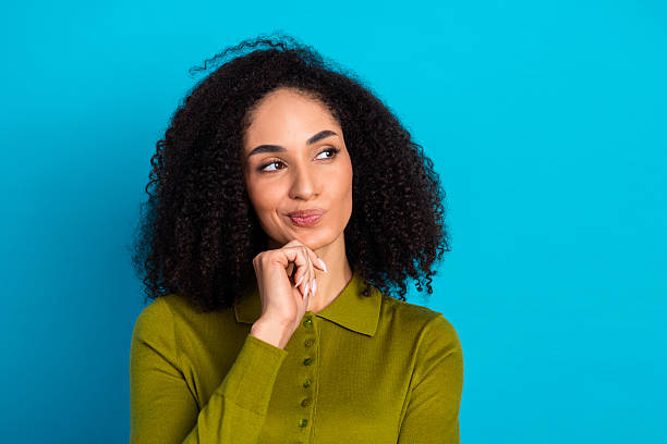 istock Confident young woman expressing curiosity while maintaining a thoughtful pose against a vibrant blue background 2217537107