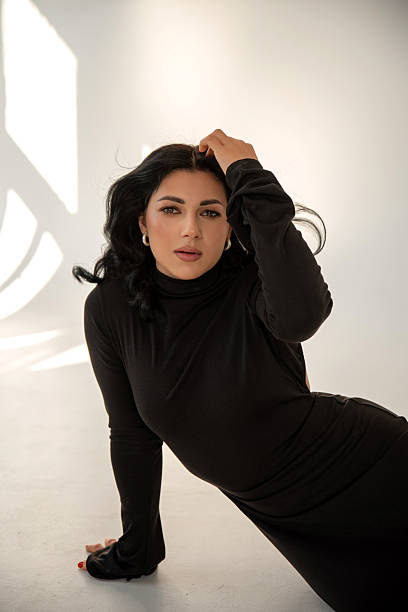 Caucasian brunette in black dress in studio
