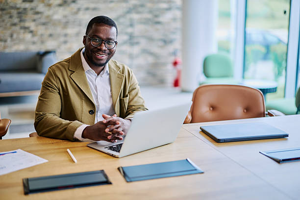 istock Confident businessman smiling at the camera while working on his laptop in the office 2217544334