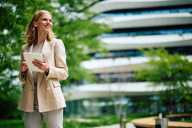 Businesswoman using digital tablet in front of modern office building