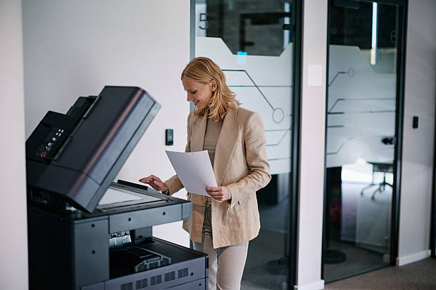 istock Businesswoman making a copy using a modern multifunction printer in the office 2217544556