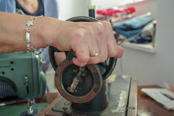 an elderly woman working at home with an old sewing machine