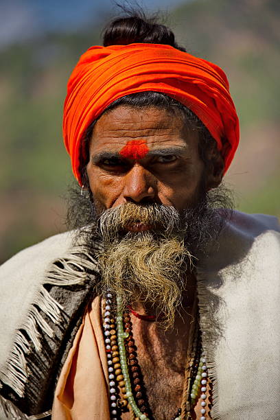 Bomdila, India. February 04, 2016. A pilgrim in a red turban and bright clothes is resting before another trip to Indian shrines.