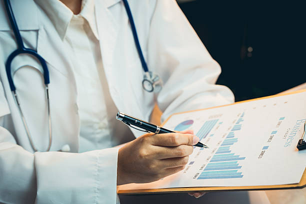 istock Medical concept. Medical Professional Analyzing Graphs and Data on Clipboard to Evaluate Patient Health Using Charts and Statistics 2217549549