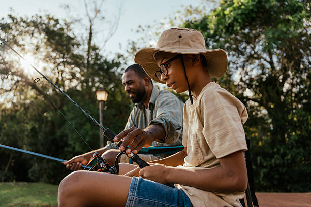 istock Father helping son with fishing 2217550312