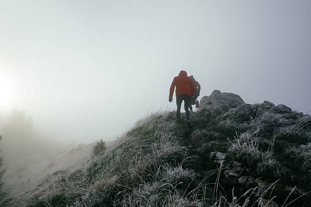 Trail running couple man and woman running on a mountain path. A couple on cross country run in early morning.
