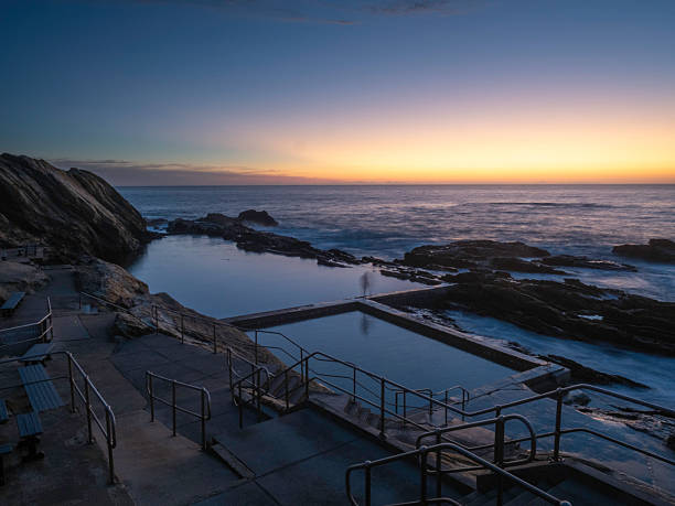 istock Sunrise stillness on rocky coastline and pool 2217556450