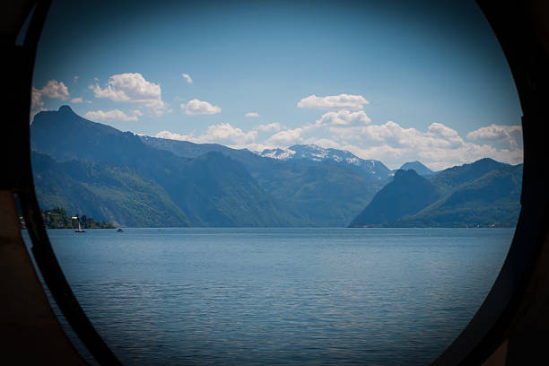 A serene view captured through circular open hole in the wall you can see the Austrian lake and mountains. Nature composition.