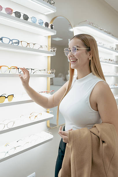 istock Smiling woman browsing eyeglasses in modern optical store 2217567444
