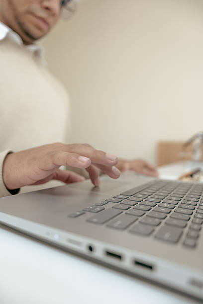 istock Close-up of hands typing on laptop in modern optical office 2217567478