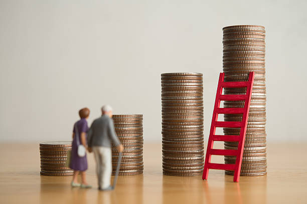 istock Old senior couple person standing looking at growth stack coins graph chart and red ladder. 2217568932