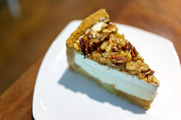 istock Salted Caramel Apple Cheesecake Slice with Nut Topping on White Plate 2217571921