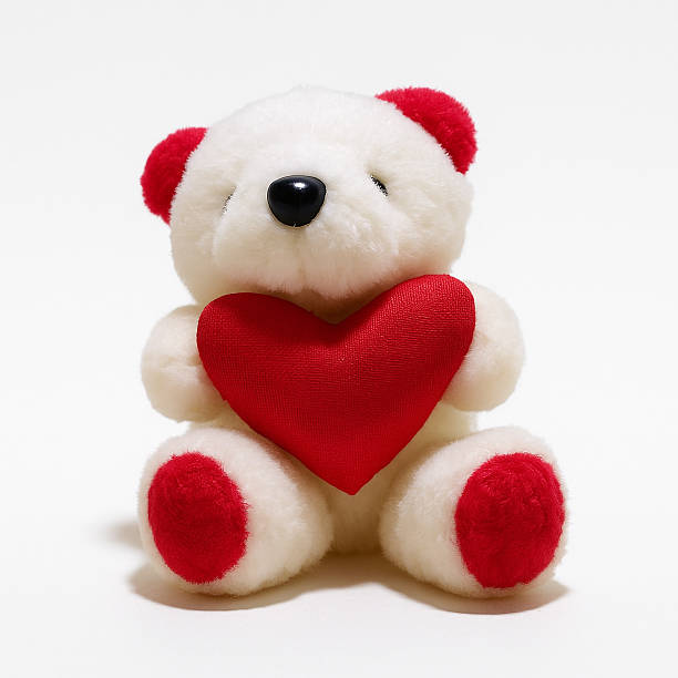istock Cute white teddy bear sitting against a white background 2217575010