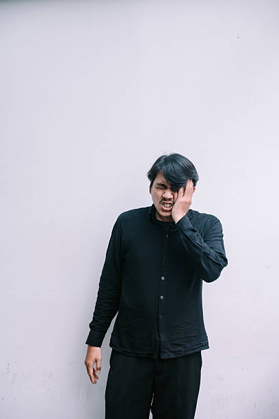 istock Man experiences intense face pain, expressing discomfort on neutral backdrop 2217579270