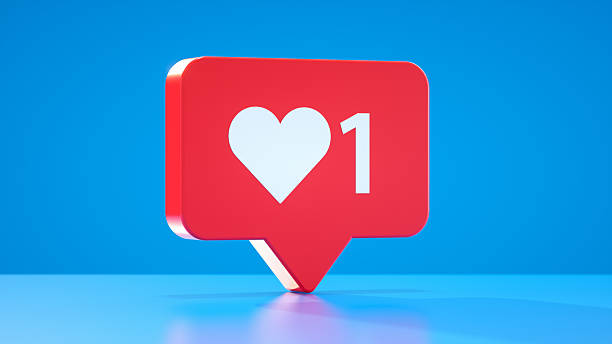 This Modern and Clean 3D Render features a Red Speech Bubble, a common Notification Icon in Social Media, displaying a White Color Heart Shape and the Number 1. Set against a Bright Blue Abstract Backgrounds with a reflective surface, this Symbol represents a new Like Button activation or a Positive Emotion Response - Message. It signifies Customer Engagement, Admiration, and Acceptance within an Online Community. This Concept is central to Social Media Marketing, Content Creation, and the User Experience of receiving Validation and fostering Connection in Digital Life Design.