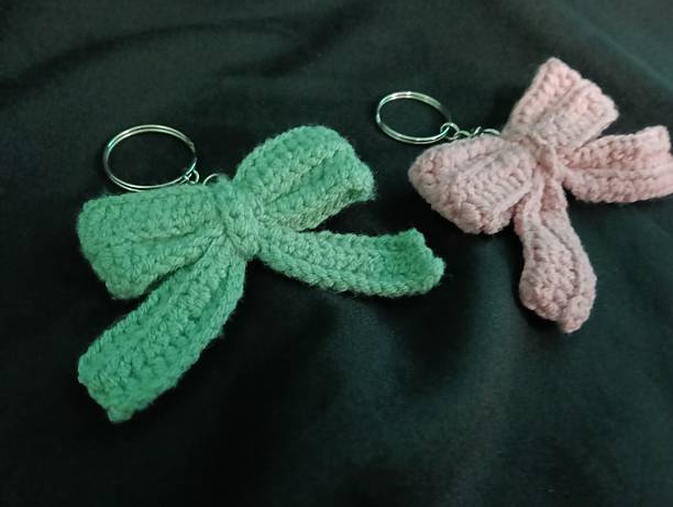 istock Handmade Crochet Keychains with Bow Designs on Dark Fabric Background 2217583002