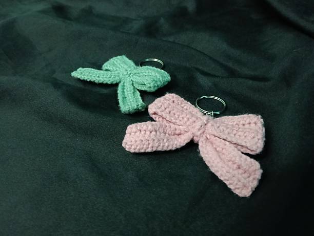 istock Handmade Crochet Keychains with Bow Designs on Dark Fabric Background 2217583014