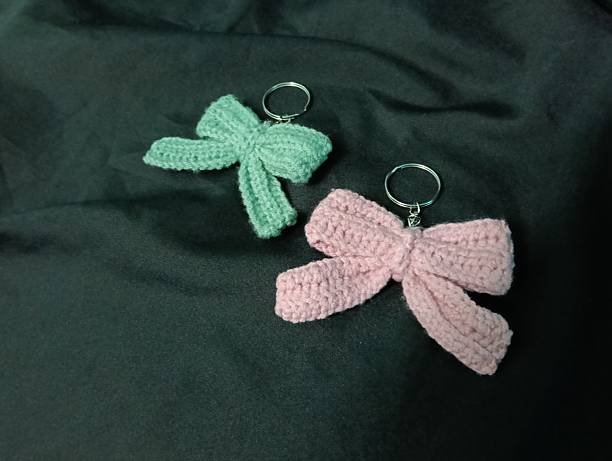 istock Handmade Crochet Keychains with Bow Designs on Dark Fabric Background 2217583018
