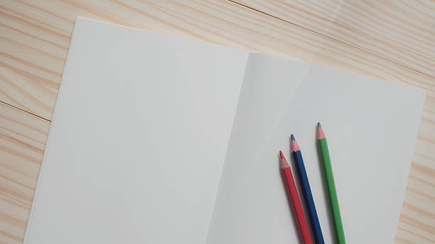 istock A minimalist top-down photo featuring a clean white sketchbook and three colored pencils on a light wooden desk. Ideal for themes of creativity, education, planning, or inspiration 2217583944