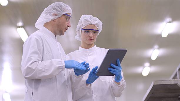 istock Quality control engineer and production line worker or product research and develop in white sterile uniforms prevent contamination of food and drink product industry or cosmetic manufacturing plants or processed food or canned food, discuss about product 2217587856