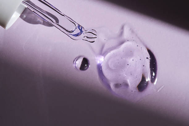 istock Pipette with serum on purple background with sunlight. 2217588126