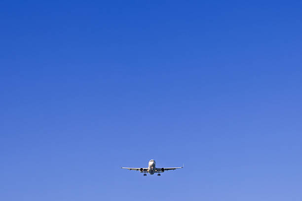 istock Airplane coming in for landing on a blue sky 2217601634