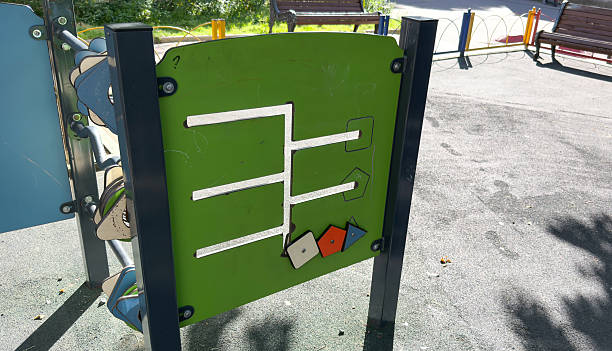Children s playground panel featuring a shape-matching maze game with movable geometric pieces on a green background1