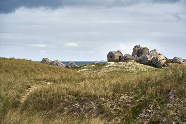 istock A small stone watch post stands on a grassy hill under a dramatic sky, showcasing the rugged beauty of Brittany. Plage des Amiets, France. 2217603295