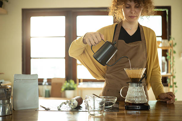 istock Calm young woman making a fresh cup of coffee using pour-over method 2217603834
