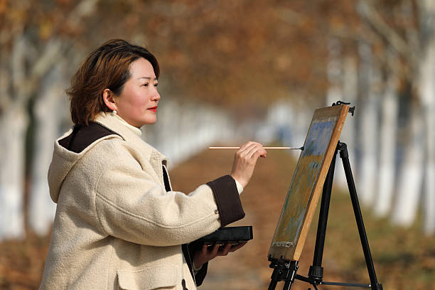 A famale painter is drawing in autumn