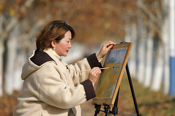 A famale painter is drawing in autumn