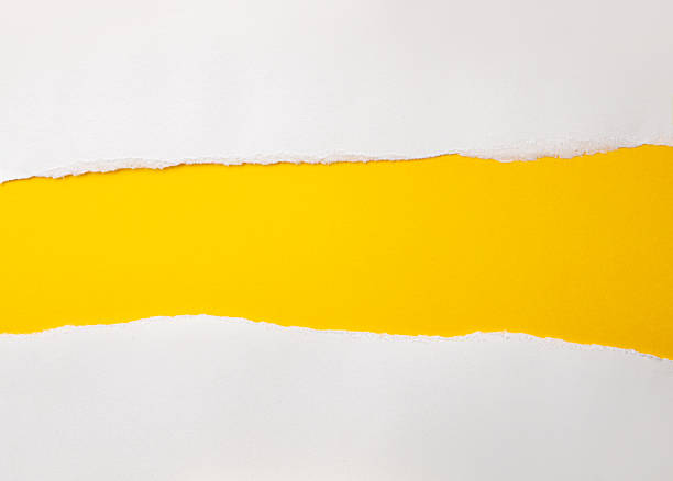 istock Hole ripped in white paper on yellow background. 2217609309