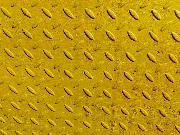 istock Yellow painted metal plate with embossed diamond background with metal sheet texture. 2217618595
