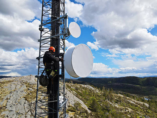 istock Engineer utility infrastructure worker at big steel mast working with radio link, microwave, 4G, 5G 2217618965